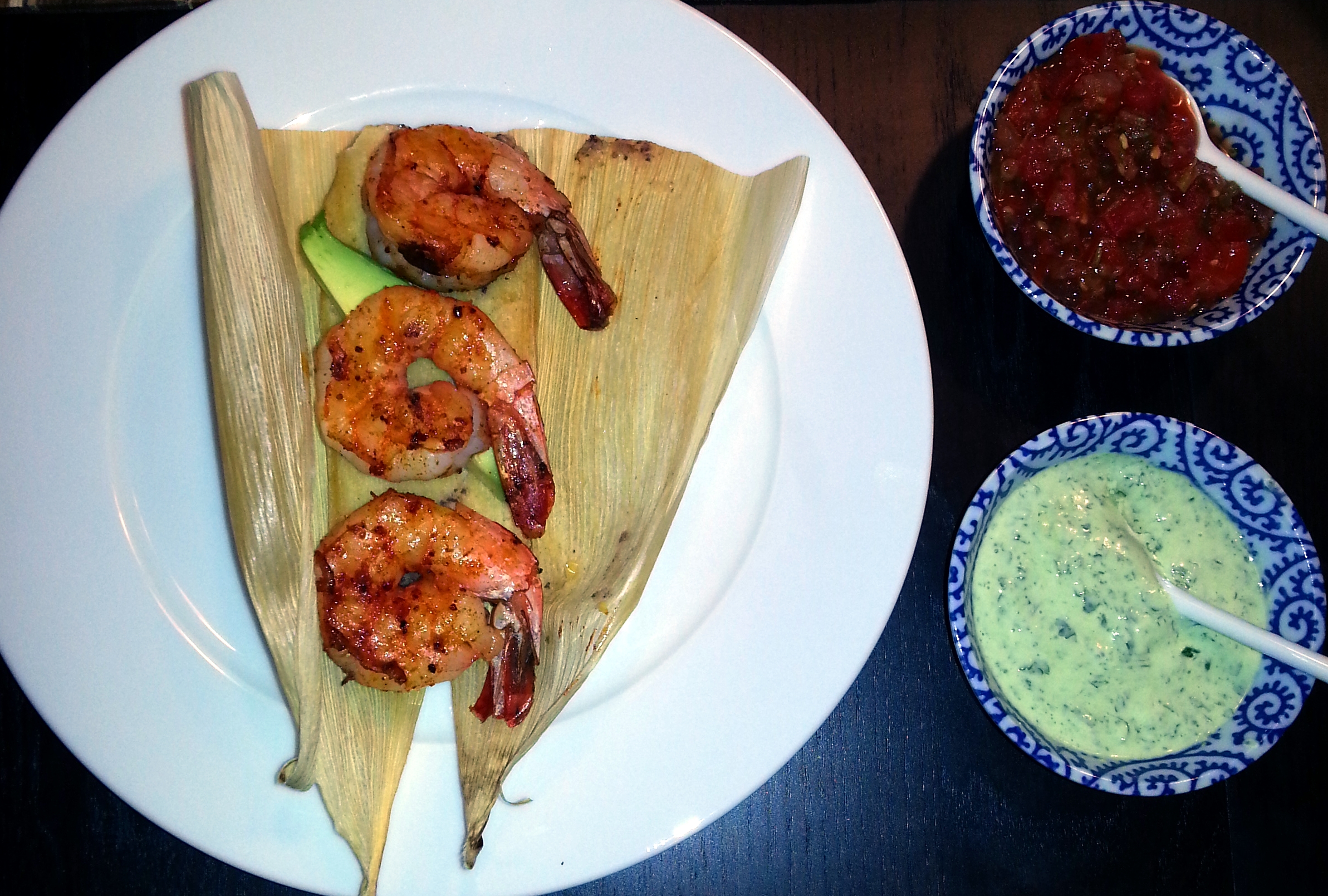 My favorite way to serve tamales: topped with ancho shrimp and served with salsa and cilantro lime crema.
